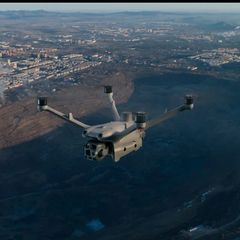 DJI Matrice 4TD thermal drone in flight over industrial inspection site with multi-sensor gimbal visible