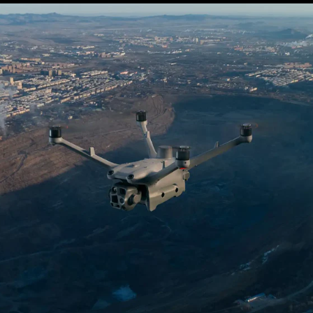 DJI Matrice 4TD thermal drone in flight over industrial inspection site with multi-sensor gimbal visible