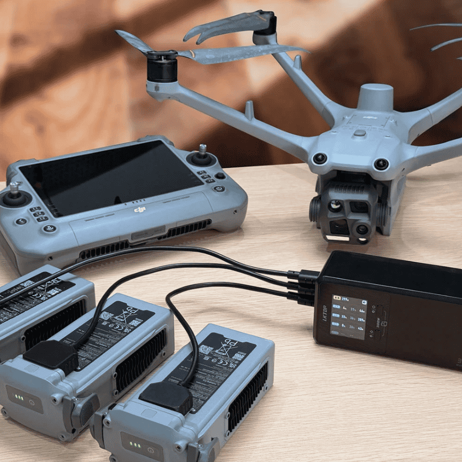 LKTOP 300W charging hub with three battery charging cradles, a DJI Matrice drone, and remote controller on a table